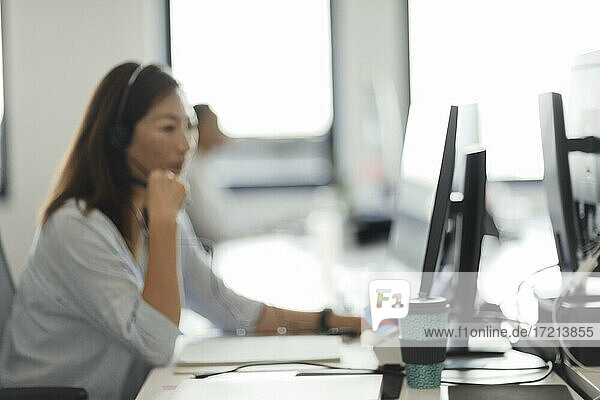 Geschäftsfrau im Headset arbeitet am Computer im Call-Center-Büro