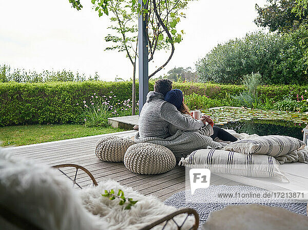 Zärtliches Paar kuscheln auf Kissen auf Luxus-Terrasse