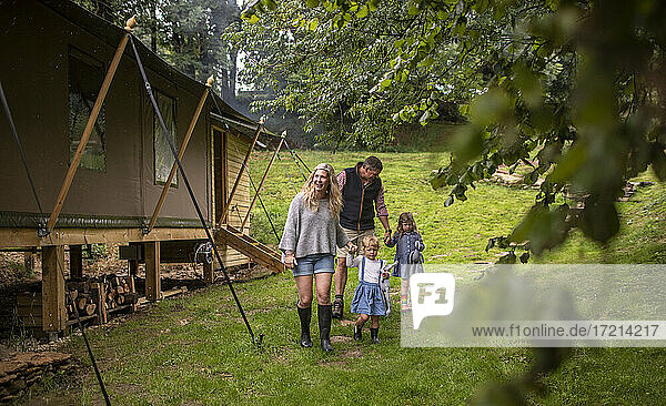 Family walking outside cabin in woods