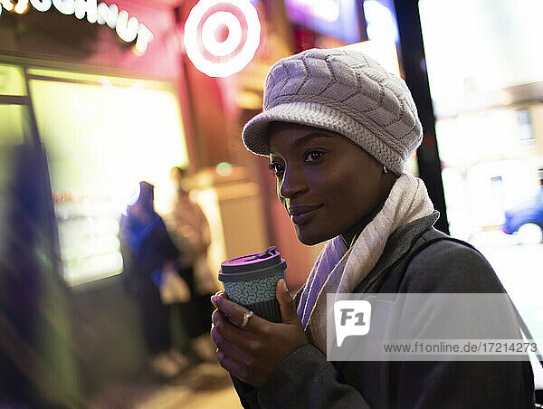 Stilvolle junge Frau in Hut trinken Kaffee auf Stadt Bürgersteig