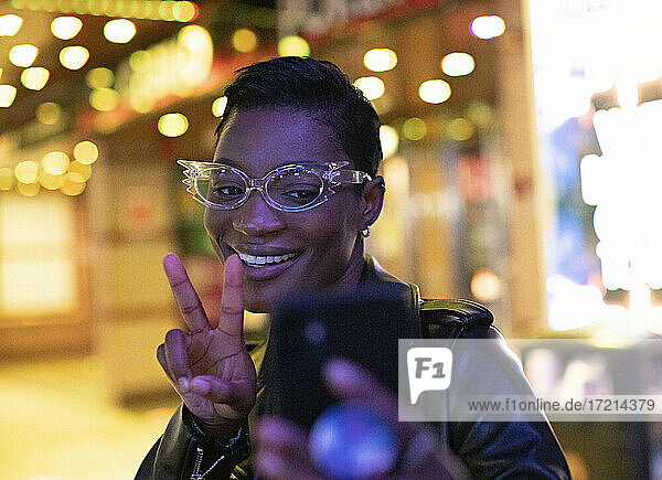 Coole junge Frau in funky Brillen nehmen selfie in der Nacht