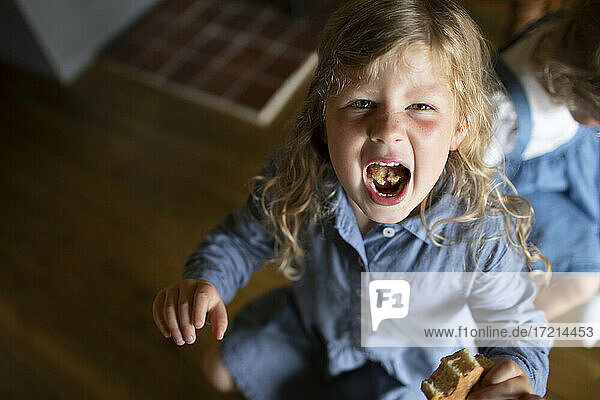 Porträt Mädchen zeigt Essen im Mund