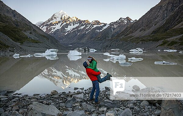 Young couple at Hooker Lake  Mount Cook in morning light  reflection in lake  sunrise  Mount Cook National Park  Southern Alps  Hooker Valley  Canterbury  South Island  New Zealand  Oceania