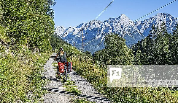 Cyclist on bike tour with mountain bike  on the bike path Via Claudia Augusta  behind Ehrwalder Sonnenspitze  Ehrwalder Becken  near Ehrwald  Tyrol  Austria  Europe