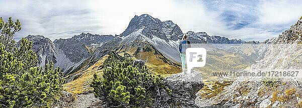 Wanderin auf einem Felsen  herbstliche Bäume  Wanderung zum Hahnkampl  links Gipfel der Lamsenspitze  Eng  Gemeinde Hinterriß  Karwendelgebirge  Alpenpark Karwendel  Tirol  Österreich  Europa