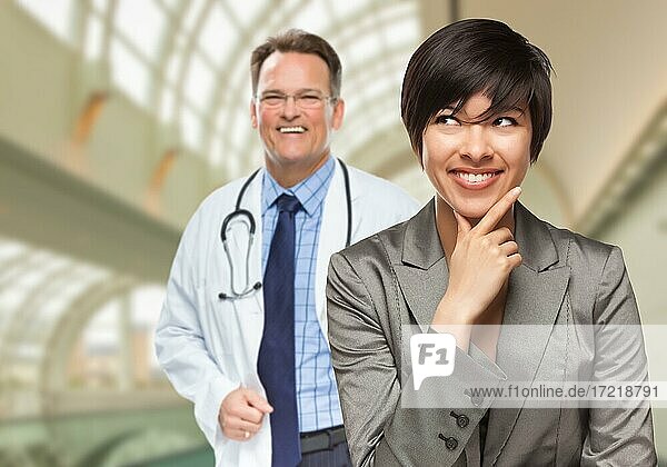 Glückliche multiethnische Frau schaut zur Seite  Arzt steht hinter ihr im Krankenhaus
