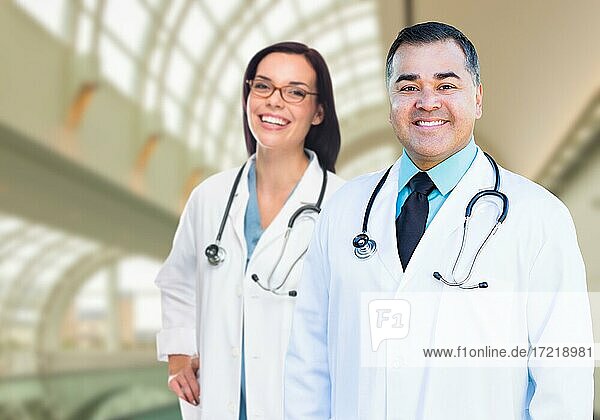Two male and female doctors or nurses standing inside hospital building