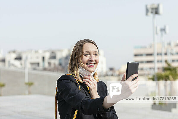Lächelnde Unternehmerin  die ein Selfie mit ihrem Smartphone macht