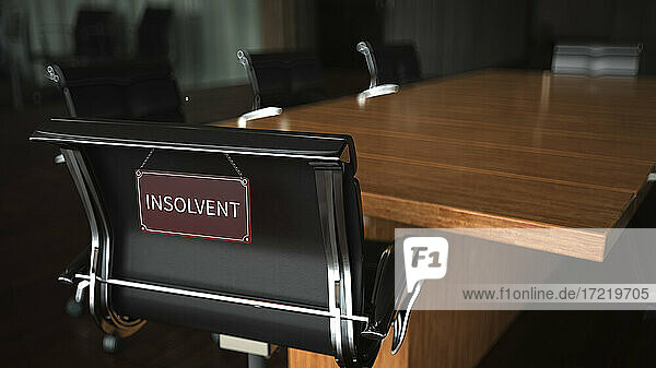 Insolvenzschild auf einem Stuhl am Konferenztisch im Büro