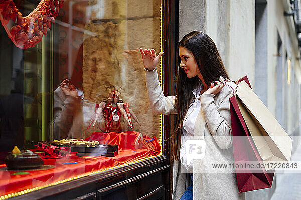 Frau mit Einkaufstüten beim Schaufensterbummel