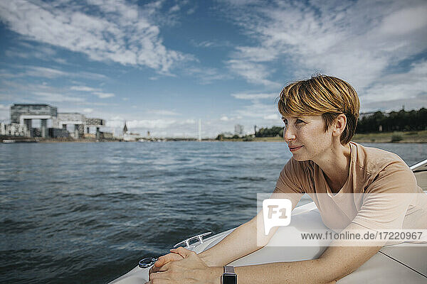 Frau mit kurzen braunen Haaren schaut weg  während sie in einem Motorboot unterwegs ist