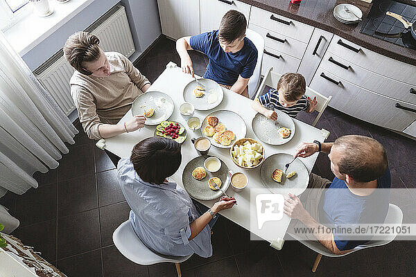 Familie isst Essen am Esstisch in der Küche zu Hause