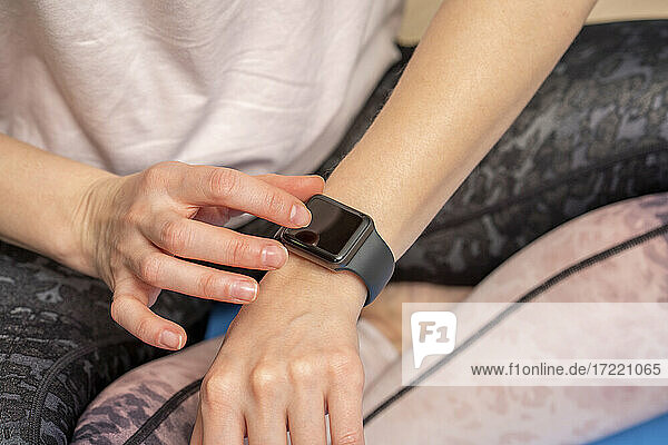 Frau benutzt Smartwatch zu Hause