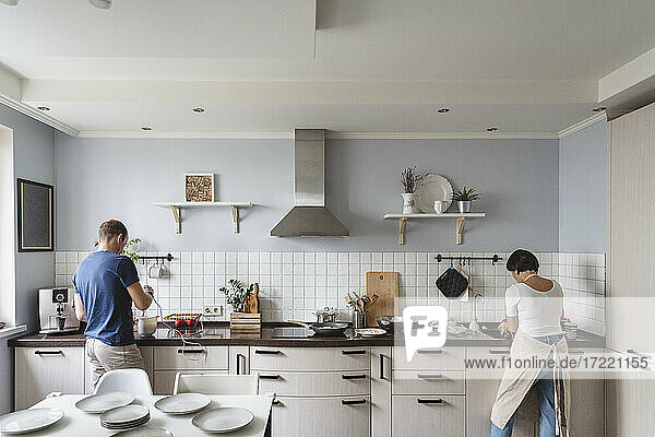 Ehemann und Ehefrau bei der Zubereitung von Speisen in der Küche zu Hause