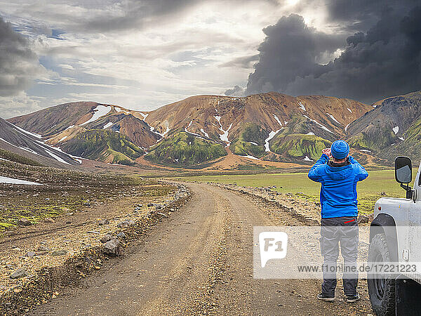 Male traveler photographing volcanic landscape of Landmannalaugar
