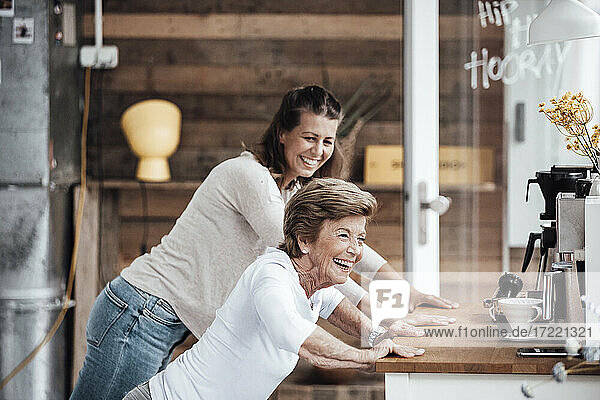 Cheerful senior woman with granddaughter exercising at countertop