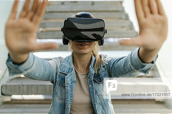 Frau gestikuliert beim Betrachten eines Videos in einem Virtual-Reality-Simulator