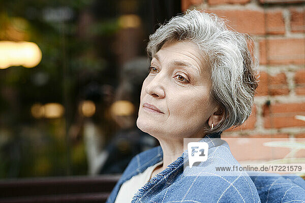 Woman day dreaming while looking away at cafe