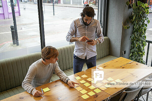 Male coworkers brainstorming while working in coworking office