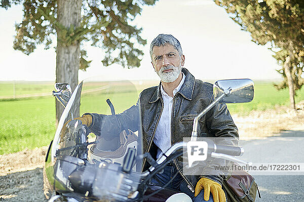 Älterer Mann auf dem Fahrrad sitzend während einer Autofahrt
