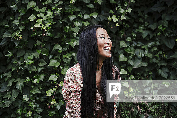 Laughing woman by plants in public park