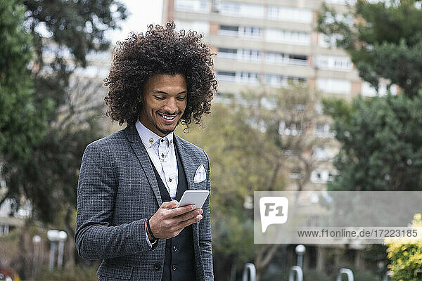 Handsome young businessman working on mobile phone in city