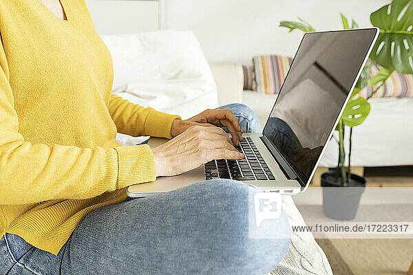 Frau benutzt Laptop im Wohnzimmer