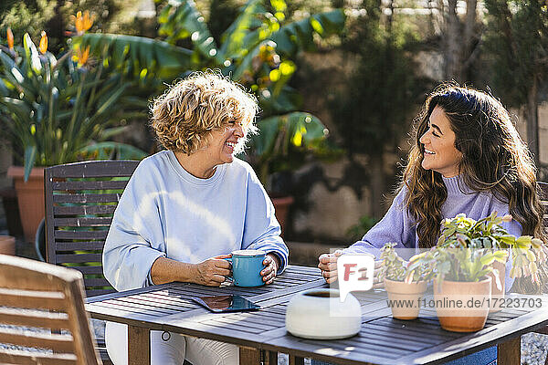 Glückliche Frauen  die im Vorgarten sitzen und Kaffee trinken