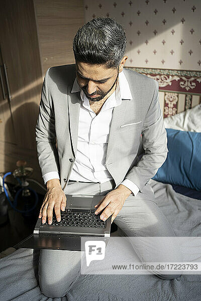 Männlicher Berufstätiger  der zu Hause am Laptop arbeitet