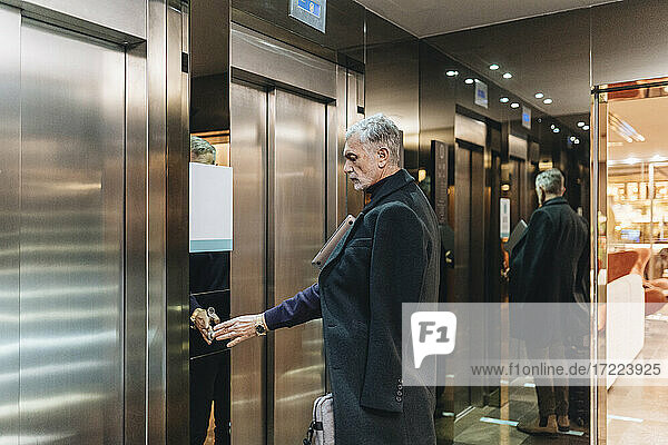 Modischer Geschäftsmann benutzt Aufzug im Hotel