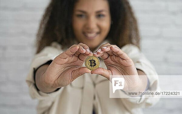 Smiling woman holding bitcoin