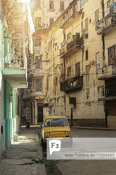 Gelbes  kleines  altmodisches Auto  geparkt am Fußweg in der Altstadt