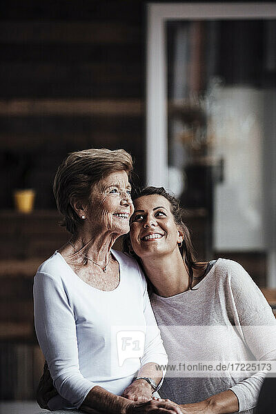 Lächelnde Enkelin betrachtet die Großmutter zu Hause