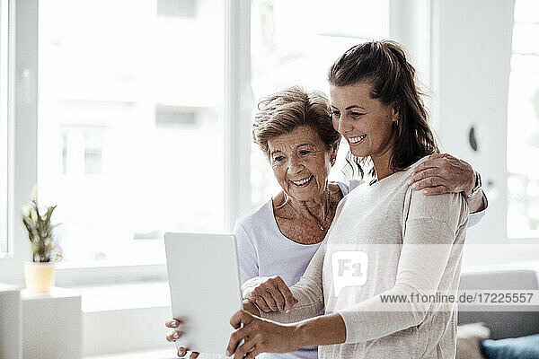 Happy woman taking selfie with grandmother at home