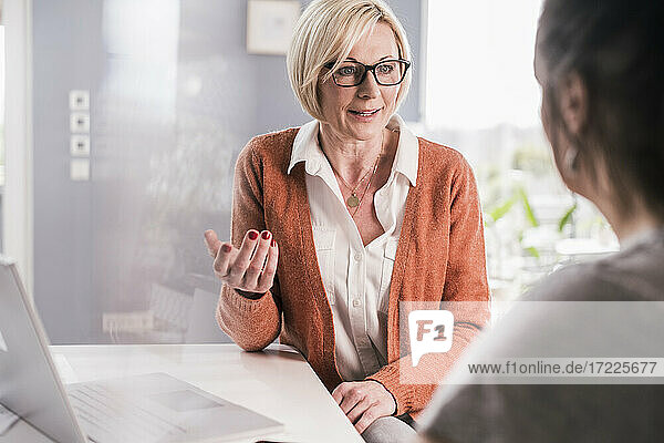 Female entrepreneur discussing business plan with female colleague in home office