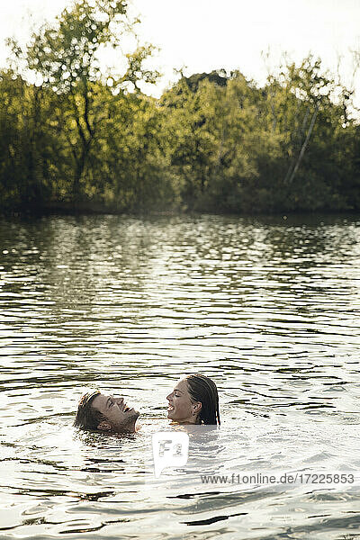Zärtliches Paar schwimmt zusammen in einem See