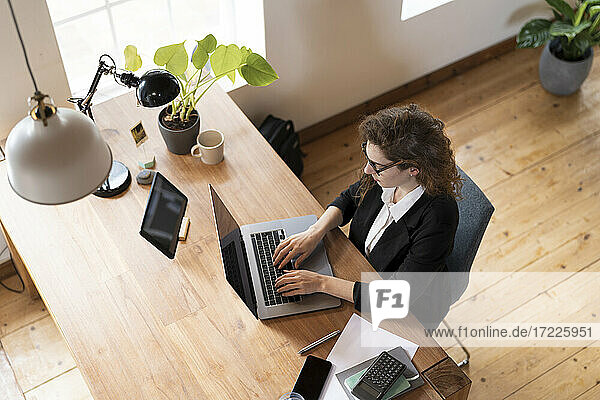 Businesswoman using laptop at home office