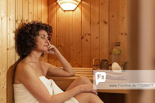 Mature woman relaxing in sauna