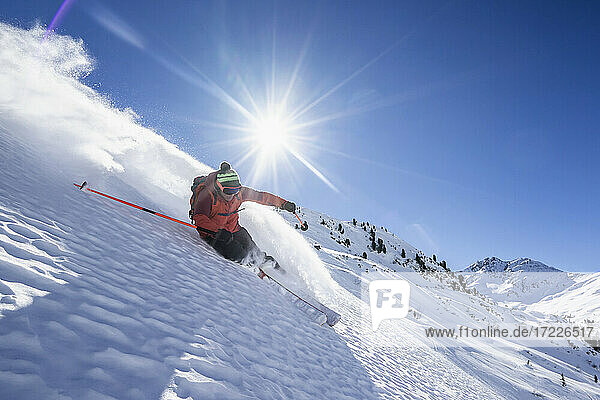 Sonnenschein über einem Mann beim Skifahren im Arlberg-Massiv