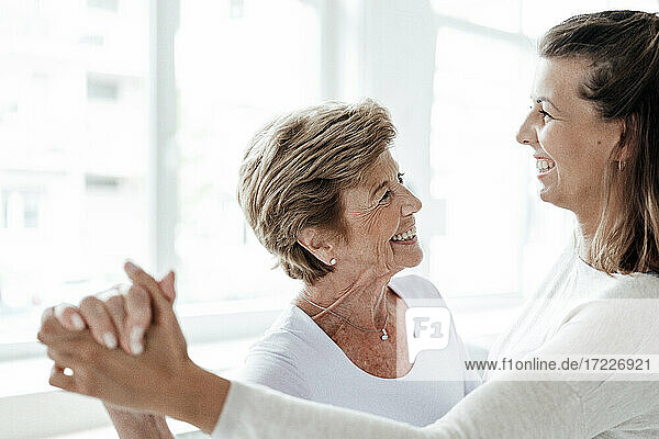 Glückliche Großmutter tanzt mit Enkelin zu Hause