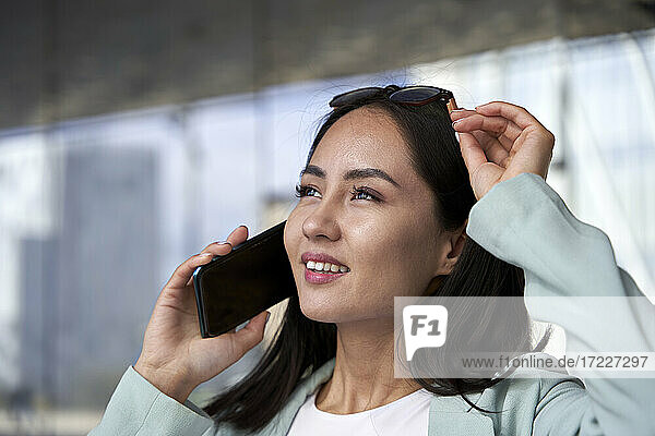 Female professional smiling and looking away while talking on phone