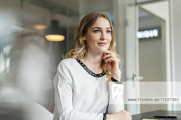 Contemplating female entrepreneur looking away at office