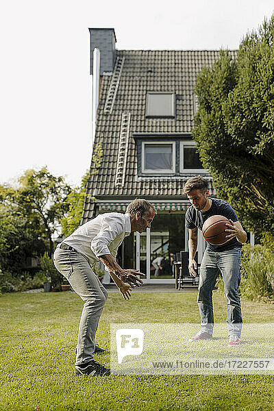 Vater und Sohn spielen Basketball im Hinterhof