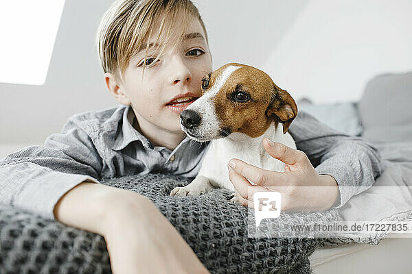 Boy with dog on bed at home