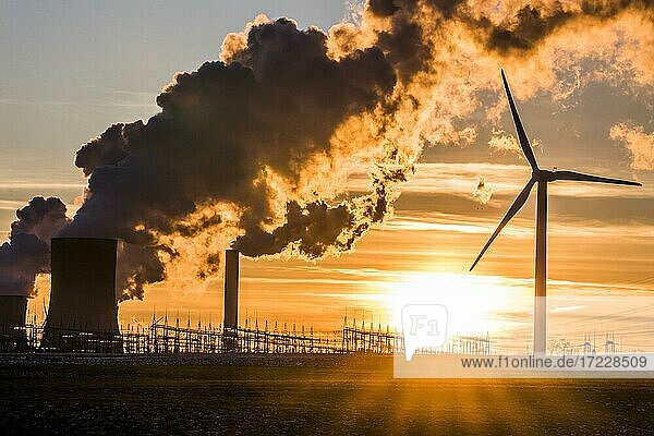 Windkraftrad vor dampfendem Kohlekraftwerk bei Sonnenuntergang  Energiewende  fossile und erneuerbare Energie  Niederaußem  Nordrhein-Westfalen  Deutschland  Europa