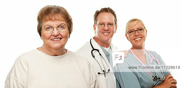 Lächelnde ältere Frau mit Arzt und Krankenschwester hinter isoliert auf einem weißen Hintergrund