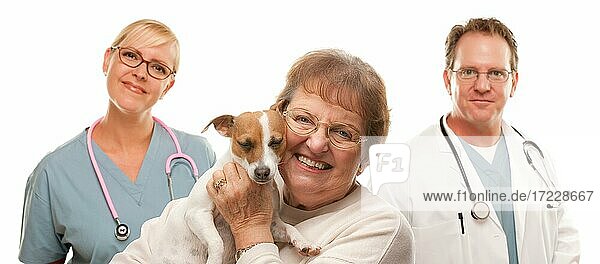 Glückliche ältere Frau mit Hund und Tierarzt und Krankenschwester isoliert auf einem weißen Hintergrund