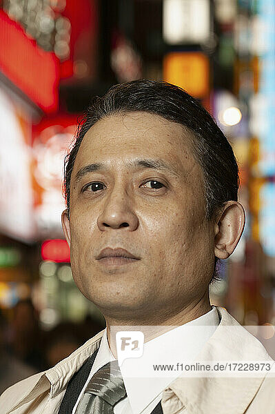 Close up portrait confident businessman in city at night