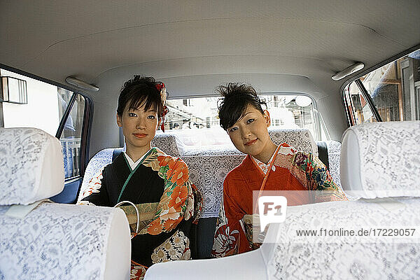 Porträt Japanische Frauen in Kimonos auf dem Rücksitz eines Autos