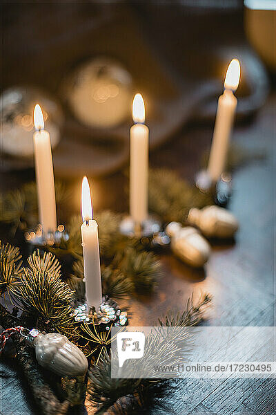 Christmas table decorations with sprigs of pine and lit candles